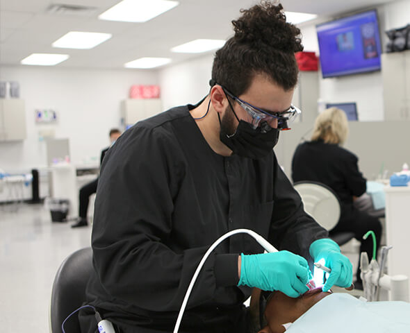 FHTC Dental Hygiene student cleaning patient's teeth