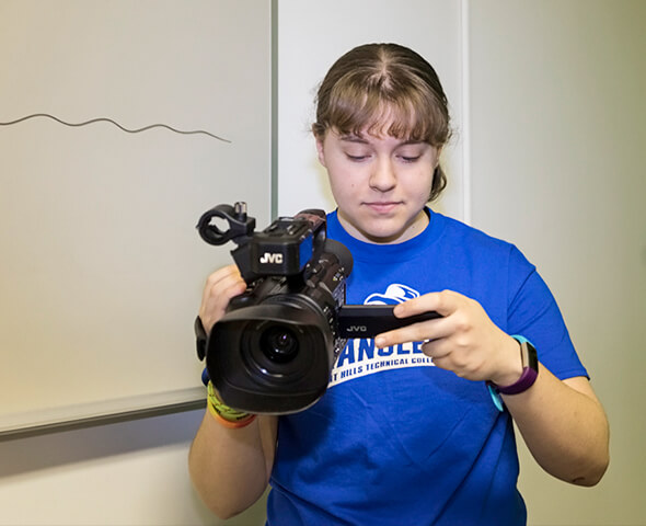 Multimedia Design student holding video camera